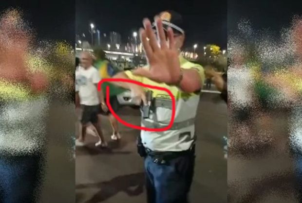 Policial de arma na mão é cercado por manifestantes na Esplanada dos Ministérios
