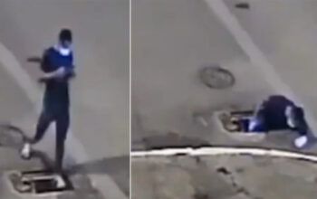 Pedestre se distrai com celular e cai em bueiro sem tampa. Veja vídeo